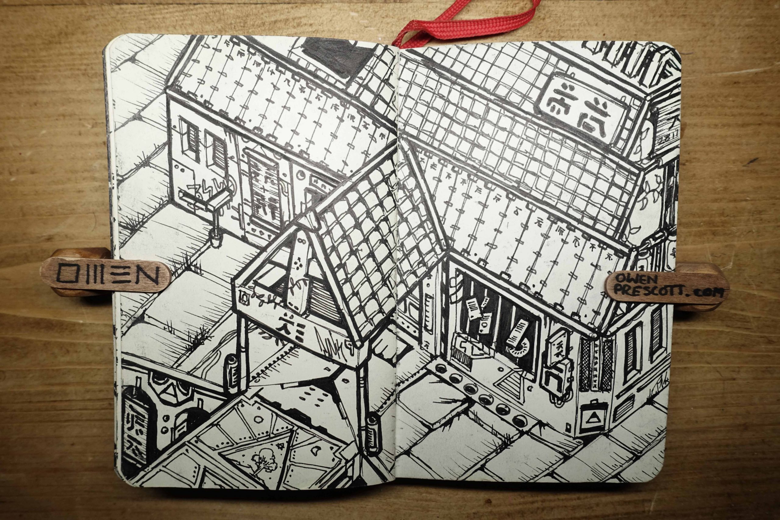 Intricate ismetric urban sketch Black and white sketch of an urban street scene with buildings and signs featuring Asian characters, drawn in a notebook held open by wooden clips on a wooden surface